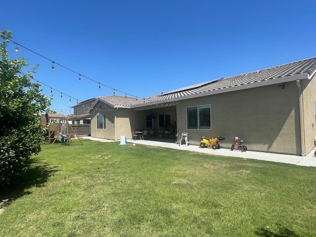 803 E Aretha Ave, Fowler, CA 93625 - back of property with stucco siding, a playground, and a patio area