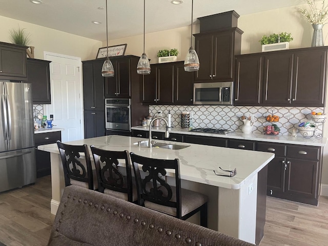 803 E Aretha Ave, Fowler, CA 93625 - kitchen featuring appliances with stainless steel finishes, light wood finished floors, tasteful backsplash, and recessed lighting