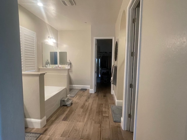 803 E Aretha Ave, Fowler, CA 93625 - bathroom with wood finished floors, a garden tub, and a spacious closet
