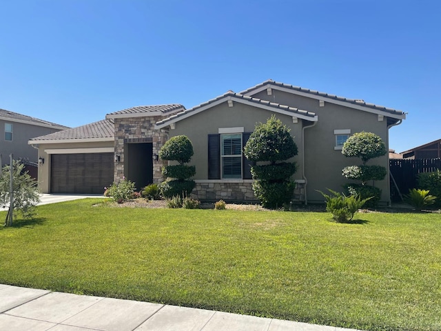 803 E Aretha Ave, Fowler, CA 93625 - view of front of home with a garage, stucco siding, a front yard, and a tiled roof