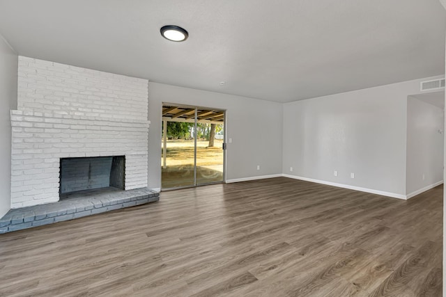 12616 E Shields Ave, Sanger, CA 93657 - unfurnished living room featuring wood finished floors and a brick fireplace