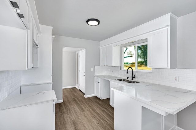 12616 E Shields Ave, Sanger, CA 93657 - kitchen featuring light stone countertops, a peninsula, white cabinets, and wood finished floors