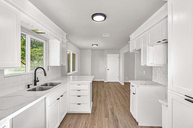 12616 E Shields Ave, Sanger, CA 93657 - kitchen with tasteful backsplash, light stone counters, light wood finished floors, and white cabinetry