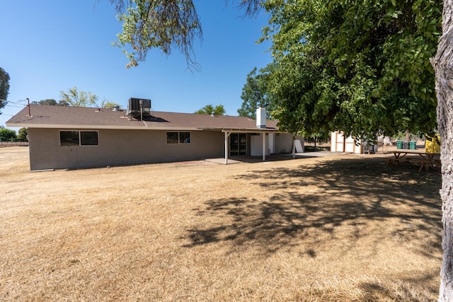 12616 E Shields Ave, Sanger, CA 93657 - rear view of house featuring stucco siding, a chimney, and a patio