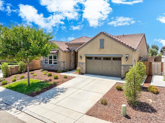 602 Pinnacle Dr W, Madera, CA 93636 - mediterranean / spanish-style home with stone siding, a garage, driveway, stucco siding, and a tile roof