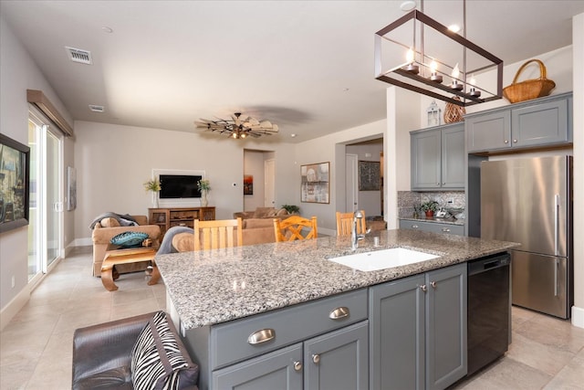 602 Pinnacle Dr W, Madera, CA 93636 - kitchen with freestanding refrigerator, dishwasher, gray cabinetry, and an island with sink
