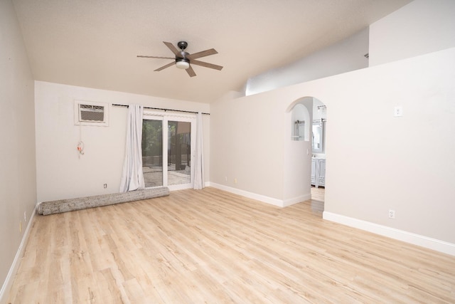 318 San Madele Ave, Coalinga, CA 93210 - empty room featuring a ceiling fan, vaulted ceiling, light wood finished floors, an AC wall unit, and arched walkways