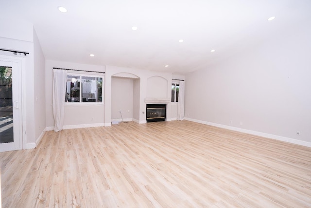 318 San Madele Ave, Coalinga, CA 93210 - unfurnished living room featuring a glass covered fireplace, recessed lighting, and light wood-type flooring