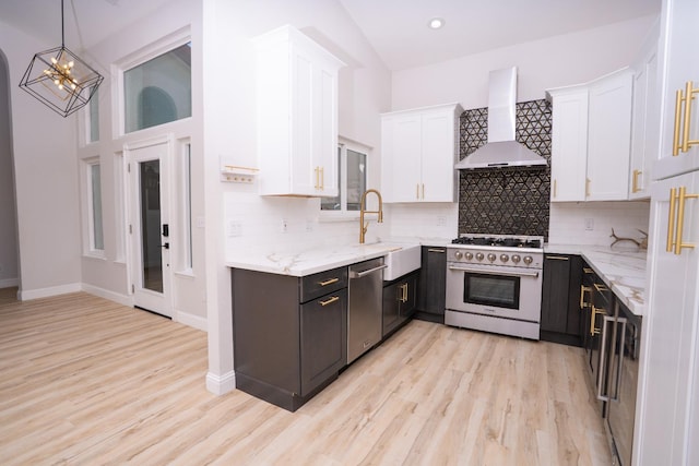 318 San Madele Ave, Coalinga, CA 93210 - kitchen with stainless steel appliances, wall chimney exhaust hood, white cabinetry, light stone countertops, and high vaulted ceiling