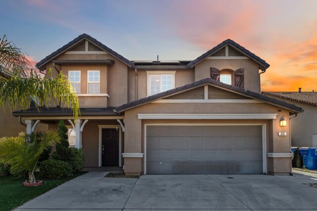 376 S Knox St, Madera, CA 93638 - view of front facade featuring driveway, solar panels, and stucco siding
