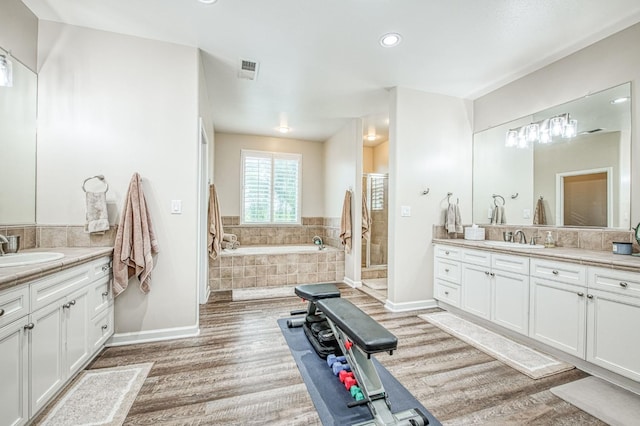 4626 N Arrow Ridge Way, Clovis, CA 93619 - full bath with wood finished floors, two vanities, a garden tub, a stall shower, and recessed lighting