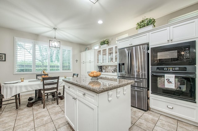4626 N Arrow Ridge Way, Clovis, CA 93619 - kitchen with black appliances, a kitchen island, light tile patterned floors, light stone countertops, and recessed lighting