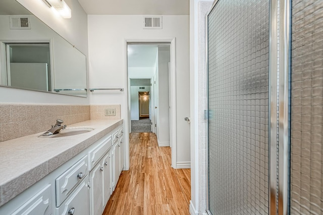1445 W Ellery Way, Fresno, CA 93711 - full bathroom with wood finished floors, vanity, a shower stall, and backsplash