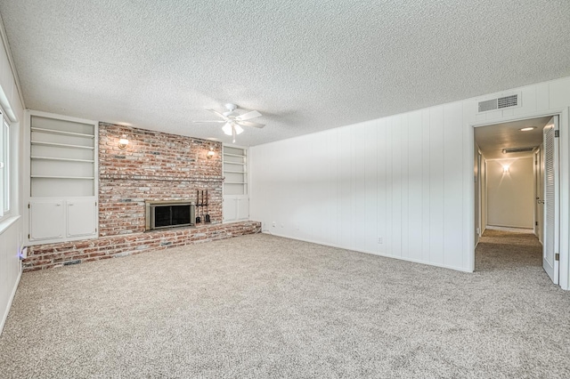 1445 W Ellery Way, Fresno, CA 93711 - unfurnished living room with ceiling fan, carpet floors, a brick fireplace, built in shelves, and a textured ceiling