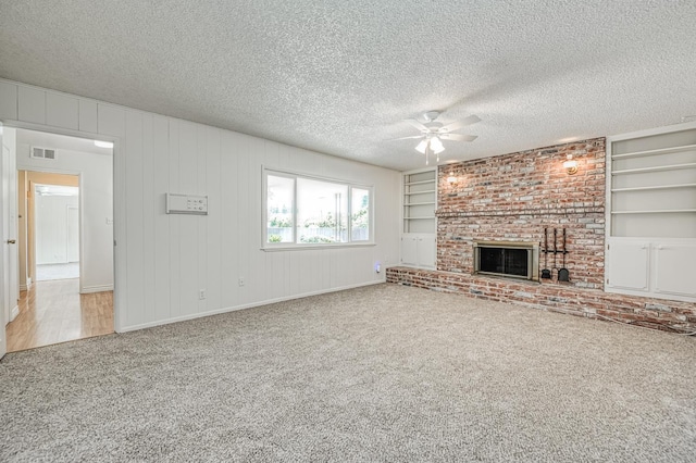 1445 W Ellery Way, Fresno, CA 93711 - unfurnished living room with a ceiling fan, carpet flooring, a fireplace, built in features, and a textured ceiling