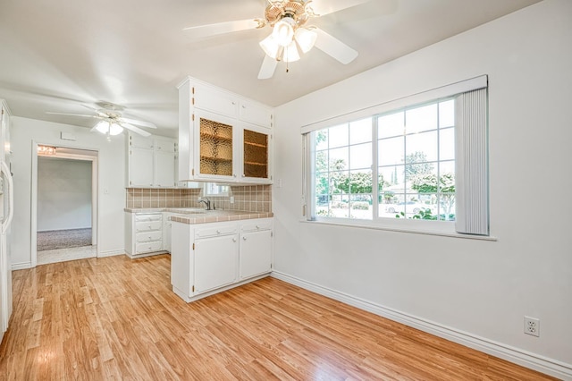 1445 W Ellery Way, Fresno, CA 93711 - kitchen featuring ceiling fan, tasteful backsplash, light wood-style flooring, white cabinetry, and tile counters
