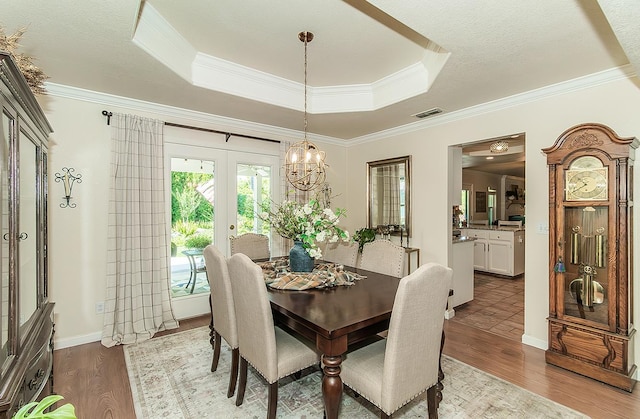 3012 Fairmont Ct, Madera, CA 93637 - dining room featuring a raised ceiling, crown molding, dark wood-style flooring, and french doors