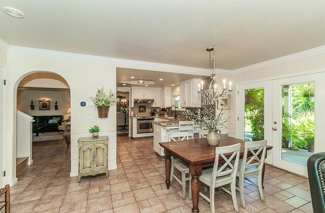 3012 Fairmont Ct, Madera, CA 93637 - dining area with arched walkways, ornamental molding, and a chandelier