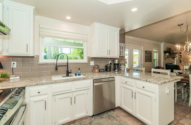 3012 Fairmont Ct, Madera, CA 93637 - kitchen with stainless steel appliances, ornamental molding, a peninsula, tasteful backsplash, and white cabinets