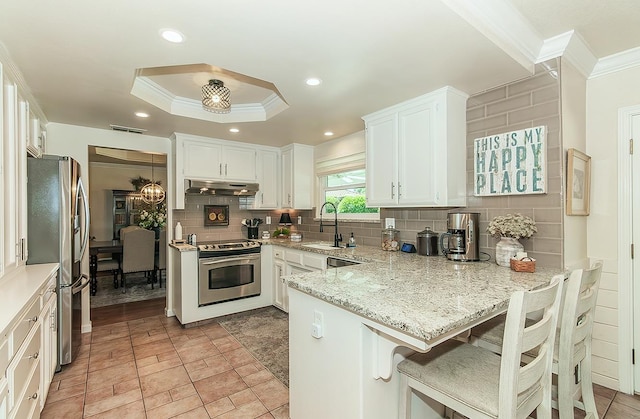 3012 Fairmont Ct, Madera, CA 93637 - kitchen with appliances with stainless steel finishes, crown molding, a peninsula, backsplash, and light stone counters