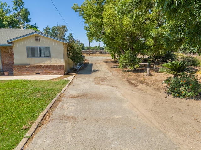3684 W Belmont Ave, Fresno, CA 93722 - view of front of house featuring dirt driveway, brick siding, and stucco siding