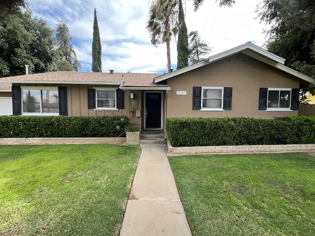 1027 W Ashcroft Ave, Fresno, CA 93705 - view of front of home with board and batten siding and a front lawn