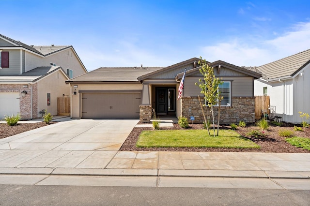 1275 Traverse Dr S, Madera, CA 93636 - view of front facade featuring an attached garage, driveway, and stone siding