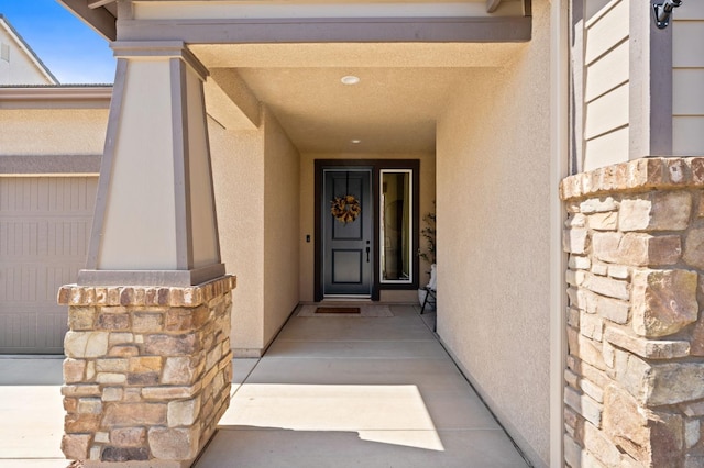 1275 Traverse Dr S, Madera, CA 93636 - doorway to property featuring stucco siding, stone siding, and a garage