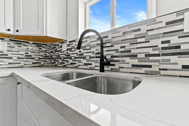 124 E 4th St, Hanford, CA 93230 - kitchen view of white cabinetry, tasteful backsplash, and light stone countertops