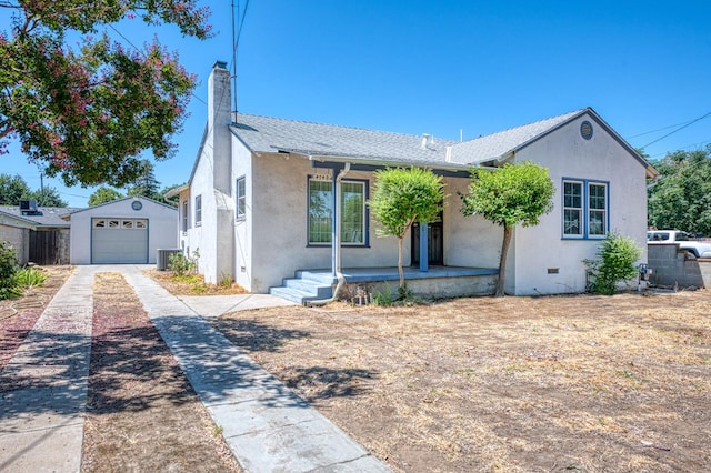 4740 E Washington Ave, Fresno, CA 93702 - view of front of property featuring driveway, stucco siding, covered porch, an outbuilding, and a chimney