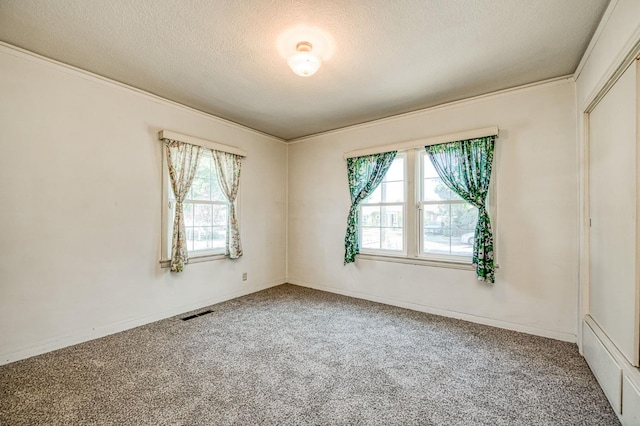 4740 E Washington Ave, Fresno, CA 93702 - spare room featuring healthy amount of natural light, a textured ceiling, carpet flooring, and ornamental molding
