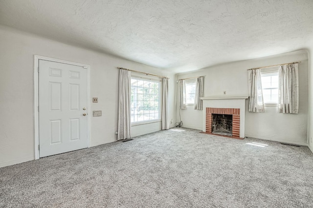 4740 E Washington Ave, Fresno, CA 93702 - unfurnished living room featuring a textured ceiling, a fireplace, and carpet floors