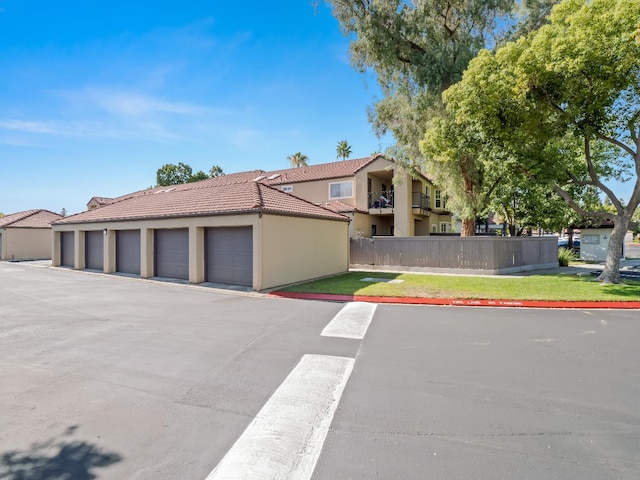 8147 N Cedar Unit 116, Fresno, CA 93720 - view of side of home featuring community garages, a tile roof, and stucco siding
