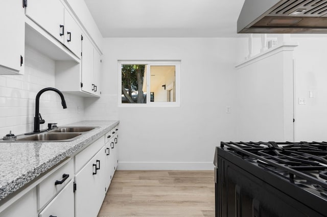 145 W Atchison Ave, Fresno, CA 93706 - kitchen featuring custom range hood, black range with gas stovetop, light countertops, white cabinets, and light wood-style floors