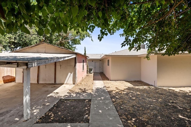 145 W Atchison Ave, Fresno, CA 93706 - back of property featuring stucco siding, a carport, and a patio