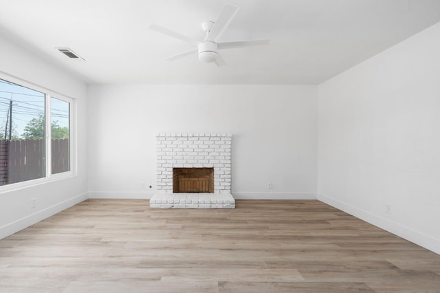 145 W Atchison Ave, Fresno, CA 93706 - unfurnished living room with light wood-style floors, a brick fireplace, and ceiling fan