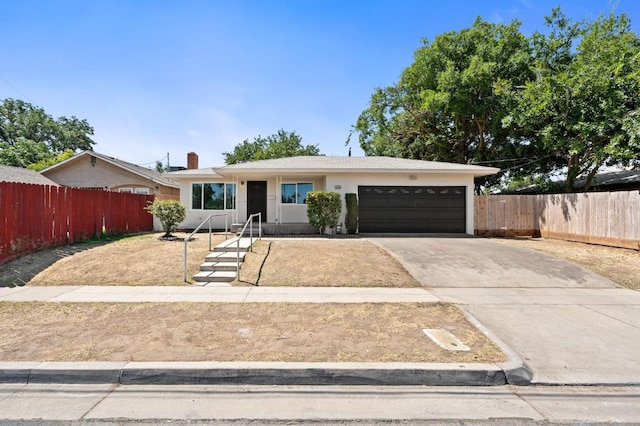 145 W Atchison Ave, Fresno, CA 93706 - view of front of property featuring an attached garage, driveway, a chimney, and stucco siding