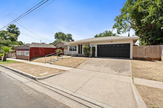 145 W Atchison Ave, Fresno, CA 93706 - ranch-style house with driveway, a garage, and stucco siding