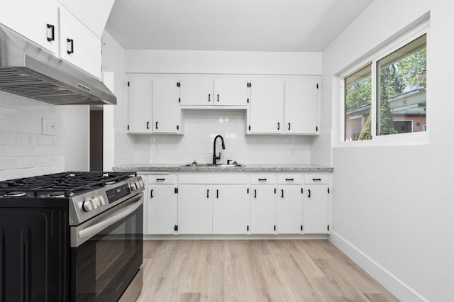 145 W Atchison Ave, Fresno, CA 93706 - kitchen featuring stainless steel gas range oven, under cabinet range hood, white cabinets, decorative backsplash, and light wood-type flooring