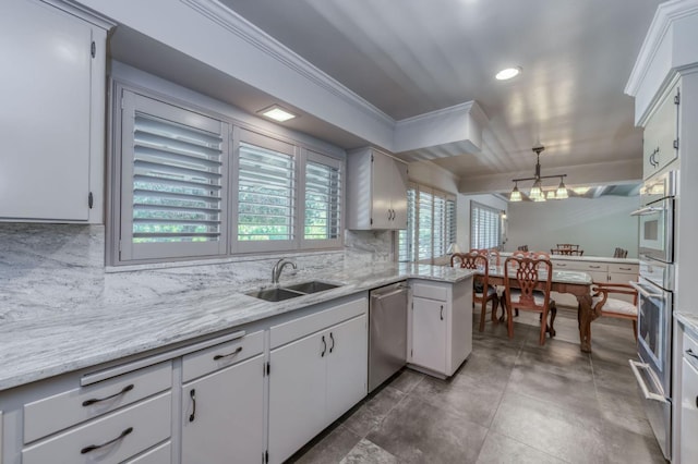 5679 N Van Ness Blvd, Fresno, CA 93711 - kitchen with appliances with stainless steel finishes, ornamental molding, backsplash, a chandelier, and white cabinetry