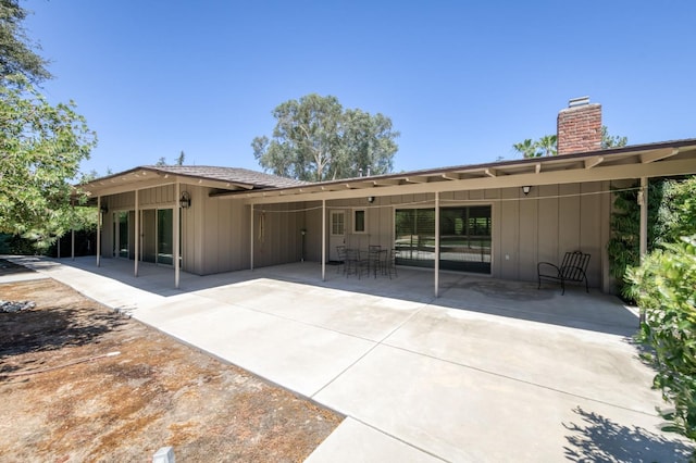 5679 N Van Ness Blvd, Fresno, CA 93711 - back of house with a chimney, a patio area, and board and batten siding