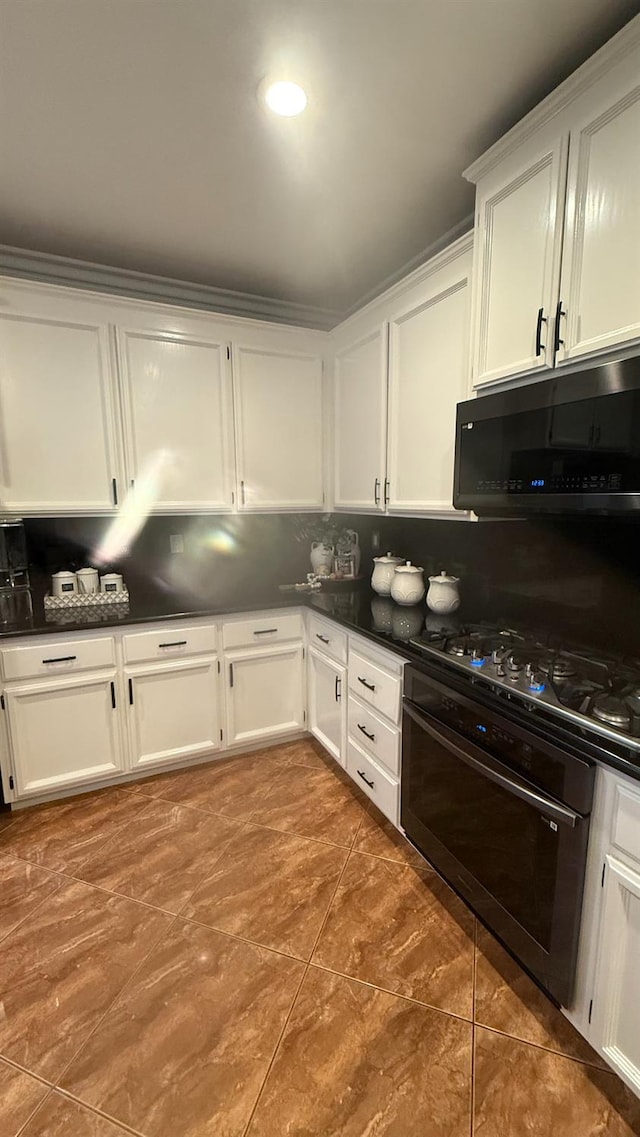 5335 E Hoxie Ave, Fresno, CA 93725 - kitchen featuring oven, decorative backsplash, dark countertops, and white cabinets