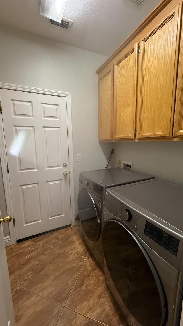 5335 E Hoxie Ave, Fresno, CA 93725 - laundry room featuring cabinet space, washer and clothes dryer, and dark tile patterned flooring