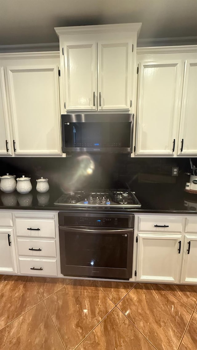 5335 E Hoxie Ave, Fresno, CA 93725 - kitchen featuring oven, gas cooktop, dark countertops, and white cabinets