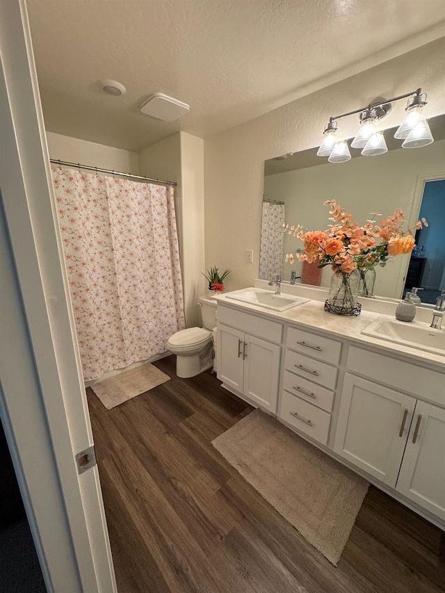 1905 George Ave, Sanger, CA 93657 - bathroom with wood finished floors, double vanity, a textured ceiling, and curtained shower