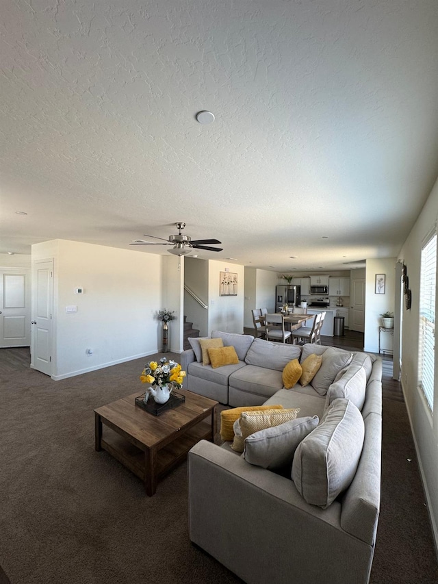 1905 George Ave, Sanger, CA 93657 - living area with dark colored carpet, stairs, a textured ceiling, and ceiling fan