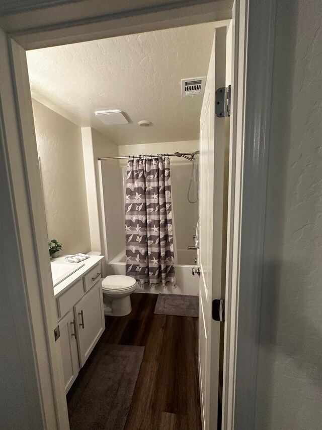 1905 George Ave, Sanger, CA 93657 - full bath with wood finished floors, vanity, shower / bath combo with shower curtain, a textured ceiling, and a textured wall