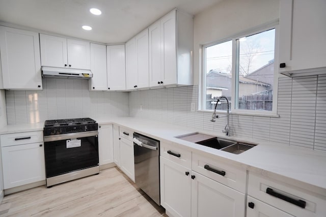 1530 E Home Ave, Fresno, CA 93728 - kitchen featuring stainless steel appliances, under cabinet range hood, light countertops, tasteful backsplash, and white cabinetry