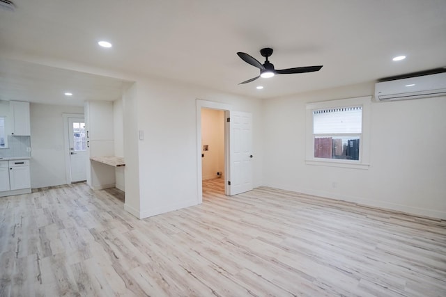 1530 E Home Ave, Fresno, CA 93728 - unfurnished room featuring a wall unit AC, light wood-type flooring, a ceiling fan, healthy amount of natural light, and recessed lighting