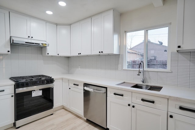 1530 E Home Ave, Fresno, CA 93728 - kitchen with appliances with stainless steel finishes, under cabinet range hood, light countertops, decorative backsplash, and light wood-style floors